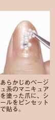 あらかじめベージュ系のマニキュアを塗った爪に、シールをピンセットで貼る。